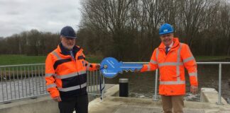Overdrachtsmoment: projectmanager oberhandigt symbolische sleutel aan bestuurder van het waterschap