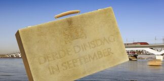 Prinsjesdag-koffertje tegen achtergrond van rivier met spoorbrug