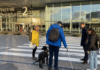 Frouck de Boer en Peter Waalboer aan het werk om de toegankelijkheid van Schiphol te verbeteren voor mensen met een visuele handicap. Ze staan buiten voor Vertrekhal 2 en bespreken een geleidelijn bij een voetgangersoversteekplaats