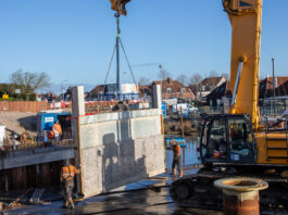 Het inhijsen van de hangelementen van de brug. 